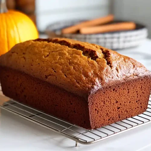 Freshly baked Pumpkin Banana Bread cooling on a wire rack with a golden crust.