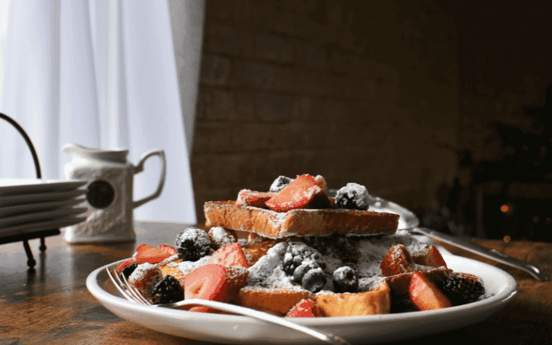 Sourdough French Toast garnished with powdered sugar and fresh berries.