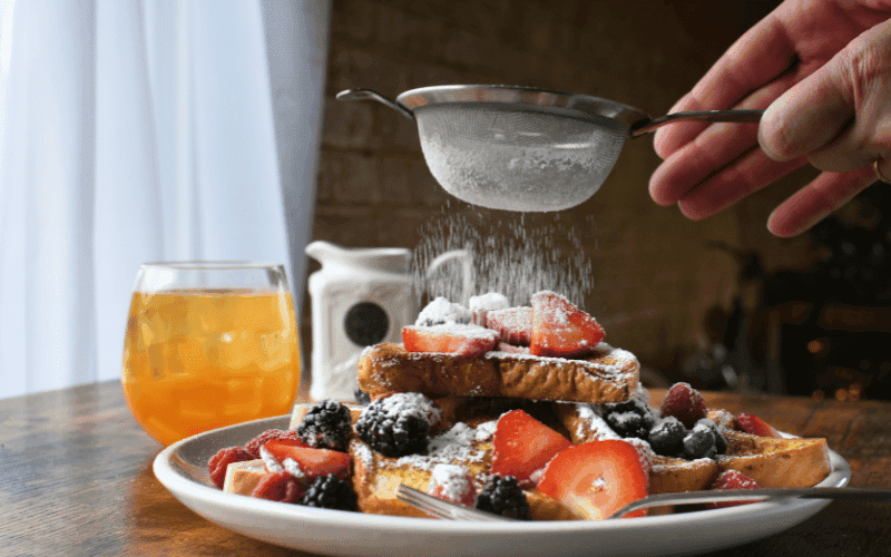 Sourdough French toast frying in a skillet until golden-brown and crispy.