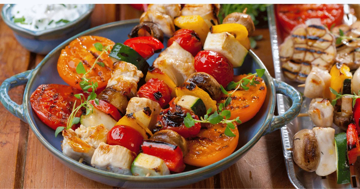 Grilled chicken skewers served with colorful grilled vegetables