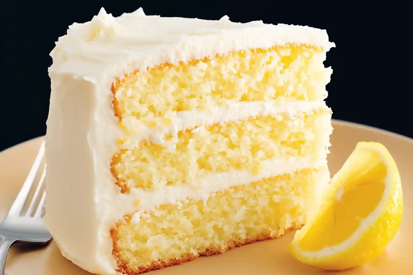 A freshly baked sugar free lemon cake cooling on a wire rack, golden brown with a light glaze on top.